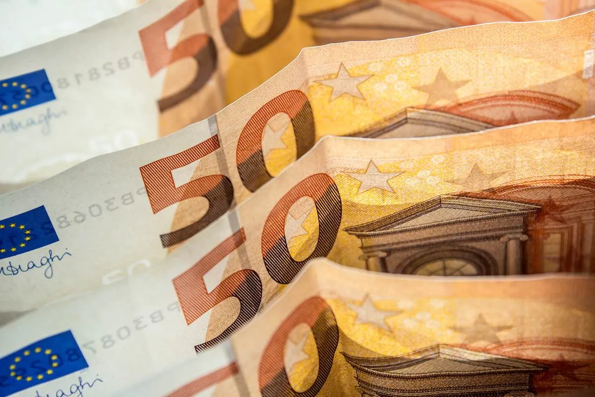 Mehrere 50-Euro-Scheine liegen fächerförmig übereinander, Nahaufnahme mit Sternen und Fensterbogen der Geldscheine